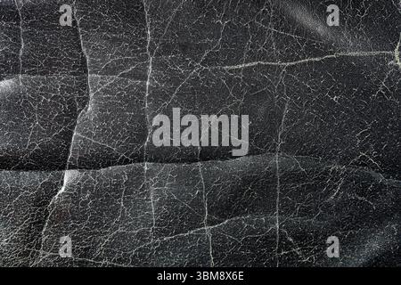 Old, weathered, cracked black leather texture close-up Stock Photo
