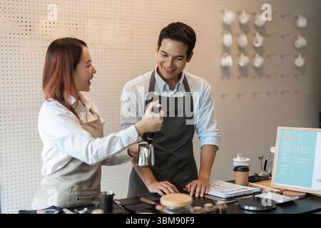 Teamwork and Coffee Brewing Skills. Two baristas enthusiastically collaborating in the cafe, sharing knowledge and brewing techniques for a delicious Stock Photo