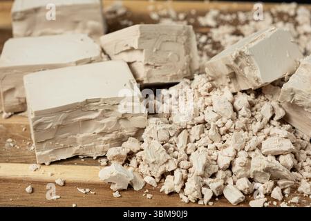 Compressed fresh yeast cubes close-up on a wooden background Stock Photo
