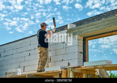 construction worker is working on scaffolding in a private house under construction Stock Photo