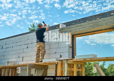 construction worker is working on scaffolding in a private house under construction Stock Photo