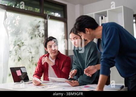 Brainstorming and UIUX Design. A creative team collaborates on user interface ideas and design concepts in a modern workspace. Stock Photo