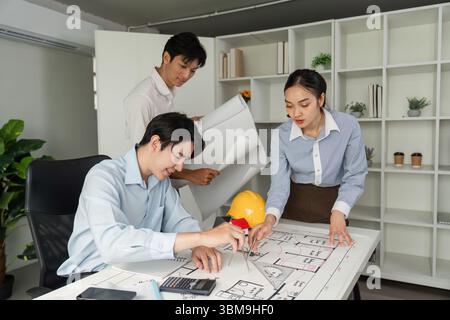 Collaboration and Planning. A team of architects working together on building designs, analyzing blueprints and discussing project details. Stock Photo