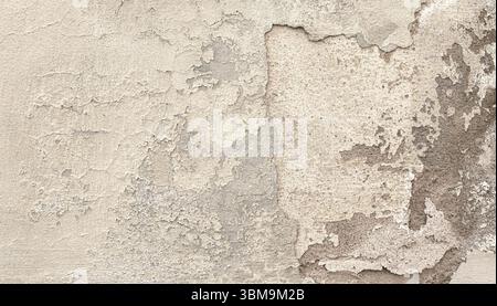 Weathered plaster wall revealing concrete underneath, creating a textured, vintage background Stock Photo