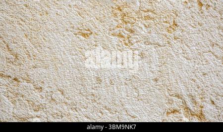 Close-up view of a weathered limestone wall, highlighting its rough texture and aged appearance, suitable for backgrounds and textures Stock Photo