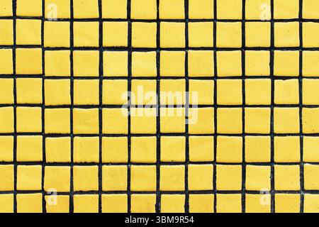 Yellow tiles with black grid. Geometric pattern with contrast colors. Abstract background of squares. Urban wall design. Modern decorative surface. Stock Photo