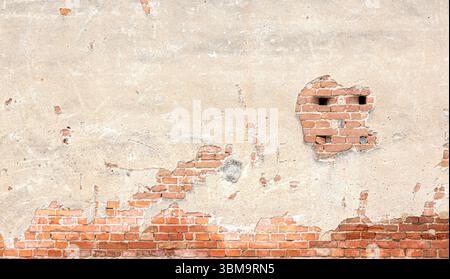 Weathered brick wall with crumbling plaster, creating a textured background with exposed red bricks Stock Photo