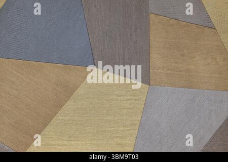 Abstract geometric patchwork fabric background with blue, brown, gold and grey panels Stock Photo