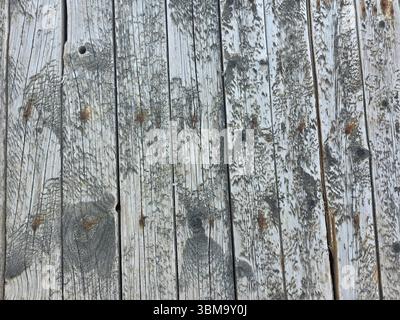 The distressed surface of old timber planks on a seaside pier, showing years of natural decay. Stock Photo