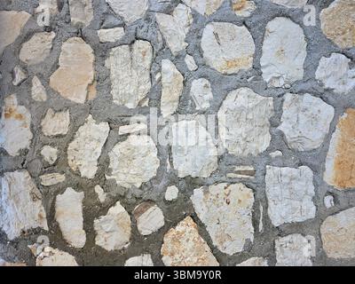 A traditional stone wall texture, creating a natural and rustic background pattern. Stock Photo