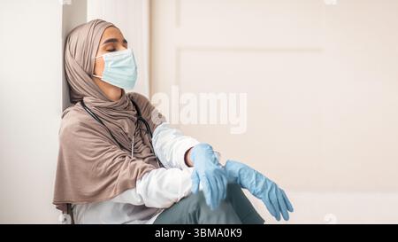Muslim woman doctor feeling exhausted, working during pandemic Stock Photo