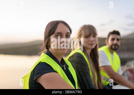 Engineers working together near water reservoir discussing project Stock Photo