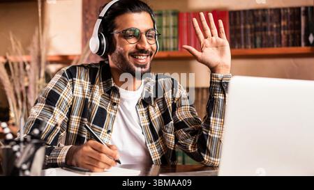 Arab Student Guy At Laptop Waving Hello Learning At Home Stock Photo