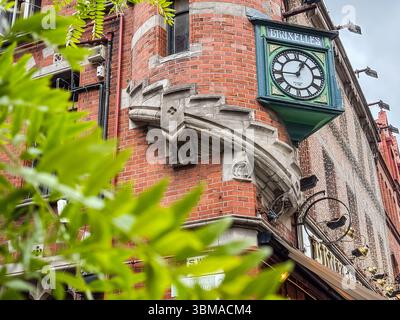Bruxelles pub clock on an historic brick building corner in Dublin, Ireland. Iconic pub facade detail. Stock Photo