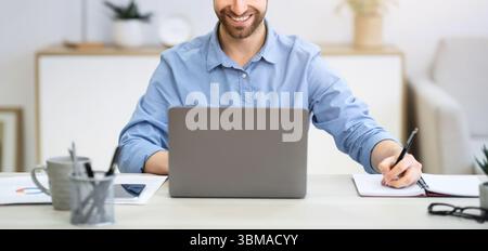 Business Guy Working Taking Notes Sitting At Laptop In Office Stock Photo
