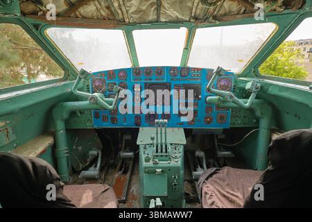 The pilot cockpit with controls, stick, instruments, gauges. An old Uzbek Airways jet passenger commercial airplane, aircraft. In Qarshi, Uzbekistan. Stock Photo
