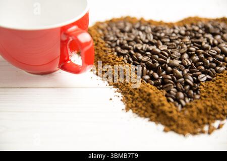 Flat design is showing red ceramic coffee cup on whitewashed wooden table with coffee bean heart Stock Photo