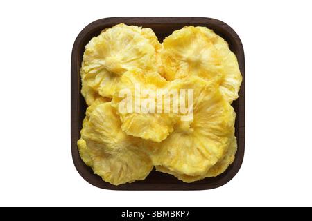dried fruit, rings pineapple in wooden bowl closeup. vegetarian food isolated on white. Stock Photo