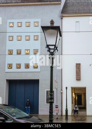 Freiburg, Germany - Feb 10, 2025: Street view of the Augustinermuseum with modern facade, wall lettering, pedestrians, and classic street lamps in rai Stock Photo