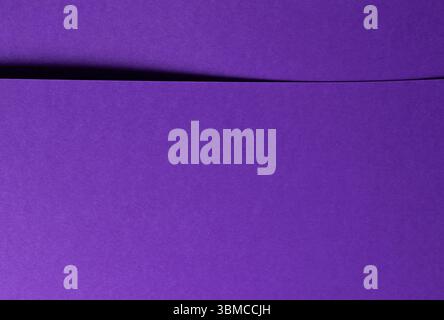 Monochrome background with overlapping sheets of designer paper in violet and purple tones. Matte surface, simple geometric lines, and elegant texture Stock Photo