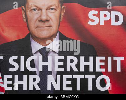 Election poster of the SPD for the federal election on 23 February 2025 with a portrait of Federal Chancellor Olaf Scholz and the (partly torn off) sl Stock Photo