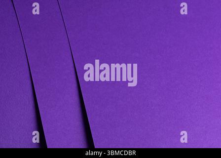 Premium designer paper in bright and dark violet purple tones with matte surface and elegant texture. Overlapping sheets form simple geometric shapes Stock Photo