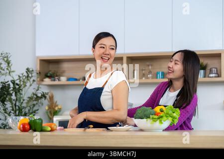 Healthy Cooking with Friends. Two women enjoying cooking together in a modern kitchen. Stock Photo