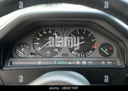 A detailed view showcasing a classic vintage car dashboard featuring the speedometer, fuel gauge, and warning lights Stock Photo