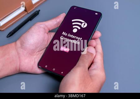 No internet access or bad connection concept. Man using smartphone with notification no internet connection. Stock Photo