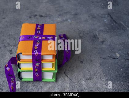 A stack of books tied with a ribbon with halloween drawings on a dark background, copy space Stock Photo