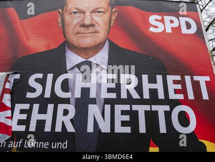 Election poster of the SPD for the federal election on 23 February 2025 with a portrait of Federal Chancellor Olaf Scholz and the (partly torn off) sl Stock Photo