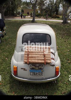 Tiny Italian Fiat 500 at a local Florida car show. This car is carrying a trunk mounted picnic basket and a blanket. Stock Photo