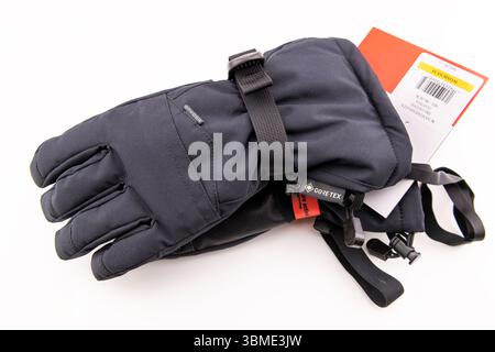 Avon, USA - August 4, 2022: Ski gloves two pair skiing outerwear gear clothes by Spyder Gore-tex technology hand holding closeup on white background Stock Photo