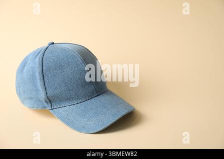 Denim baseball hat on beige background, space for text Stock Photo