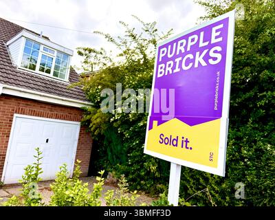 A Purple Bricks Estate Agent sign outside a house in the U.K. Stock Photo