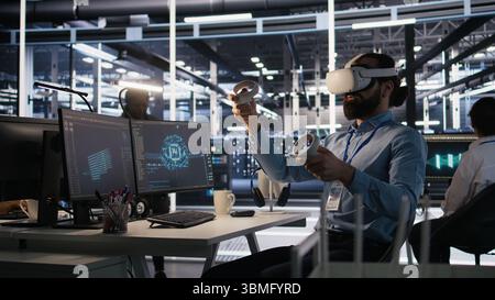 Admin using VR headset in data center to update server tech, configuring equipment using software tools. Server farm employee reviewing hardware analytics using virtual reality, camera A Stock Photo