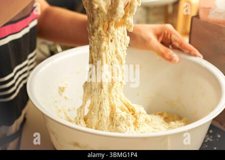 Young woman kneading dough to make bread Stock Photo