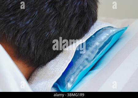 Young man resting in bed with ice pillow due to heat stroke caused by intense heat Stock Photo