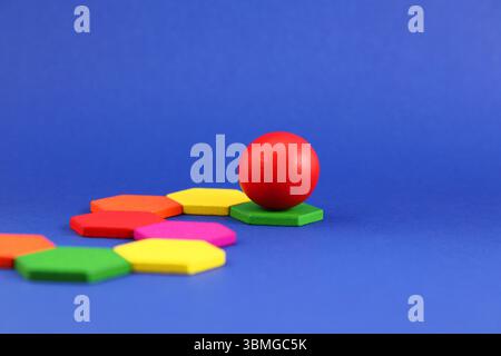 Leading sphere rolls through a path of hexagonal pieces Stock Photo