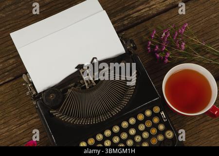Typewriter and flowers on table Stock Photo
