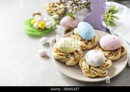 Easter composition. Sweet Italian Easter Bread Rings from puff pastry and dyed eggs on a stone background. Copy space Stock Photo