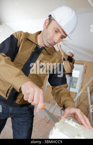 middle age builder pastering cement mortal on the brick wall Stock Photo