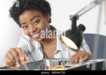 young female electronic engineer inspecting computer motherboard in laboratory Stock Photo