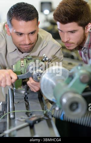 mechanic showing parts of an engine to apprentices Stock Photo