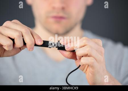 man plugging in cable to wireless router Stock Photo