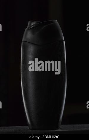 Black plastic bottle for shampoo or shower gel on black isolated background Stock Photo