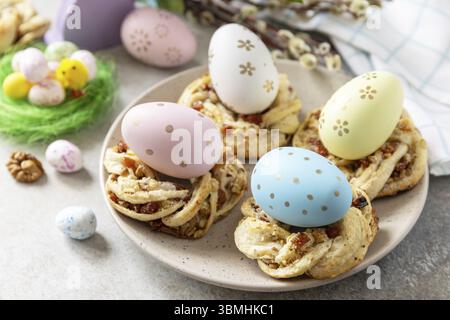 Easter composition. Sweet Italian Easter Bread Rings from puff pastry and dyed eggs on a stone background Stock Photo