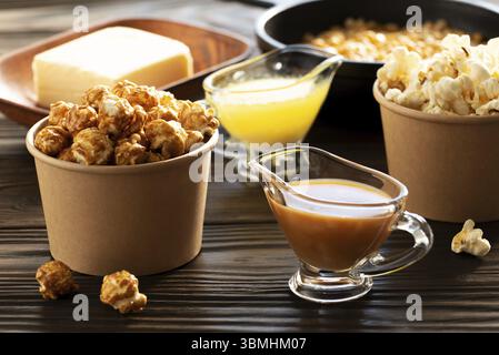 Paper buckets with butter and caramel popcorn on kitchen table Stock Photo