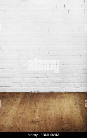 White brick wall of painted genuine clay blocks and wooden floor background Stock Photo