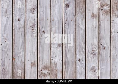 Vertical weathered planks are forming full-frame flat design showing grain and nail holes Stock Photo